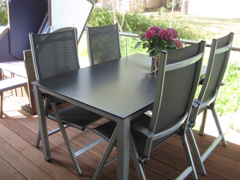 Gartentisch mit vier Stühlen auf dem Holzbalkon der Ferienwohnung in Baabe